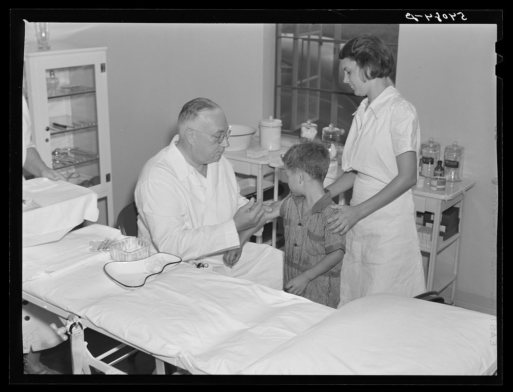 [Untitled photo, possibly related to: Dr. William J. Buck gives typhoid shot to one of camp members with Marjory Fowler, NYA…