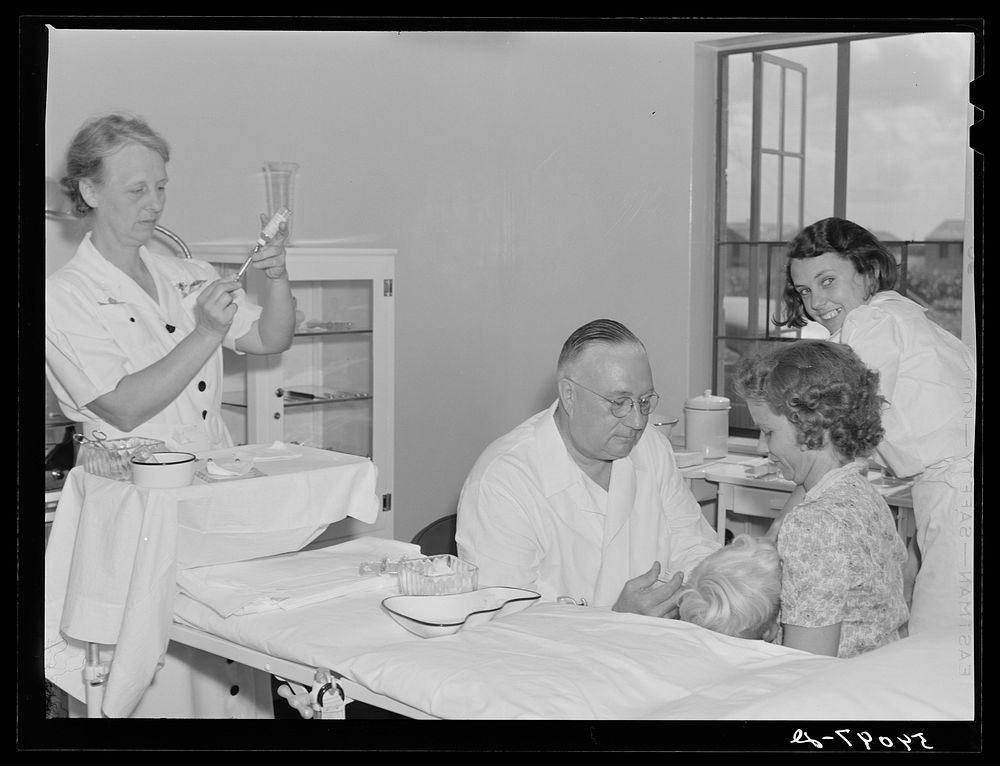 Dr. William J. Buck giving typhoid innoculation to child and mother, with Nurse Smock, and Marjory Fowler, NYA (National…