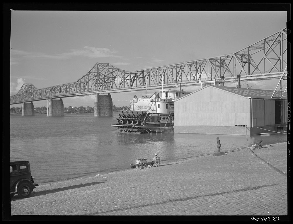 [Untitled photo, possibly related to: Riverboat carrying cargo leaving dock along waterfront on Ohio River. Louisville…