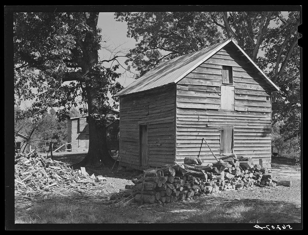 Storing barns and woodpiles on Emery Hooper's farm near Prospect Hill. Caswell County, North Carolina. Sourced from the…