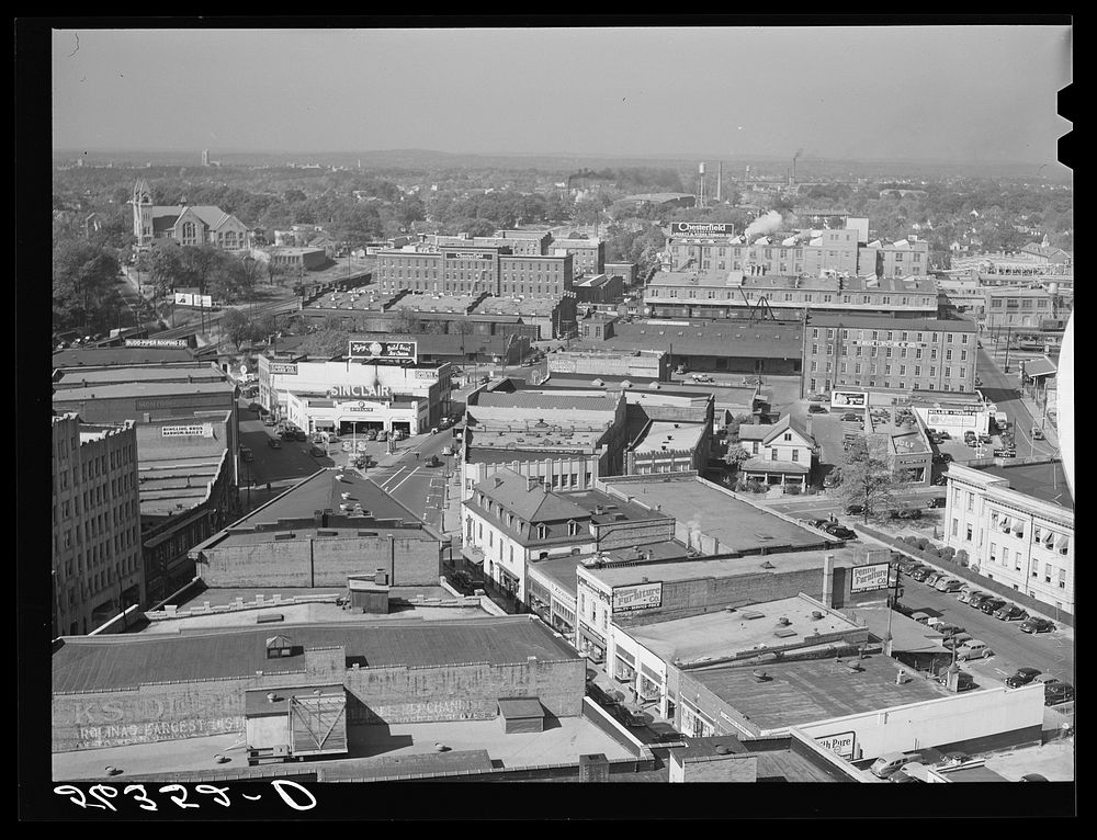 Five points, center of city, with Chesterfield cigarette factories in background. Durham, North Carolina. Sourced from the…