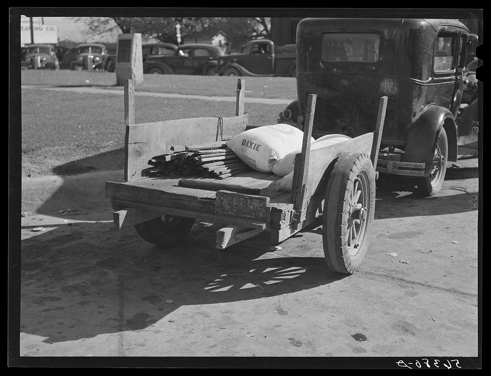 Farmer returning home after selling his tobacco at auction. In the trailer are sacks of flour and meal and the tobacco…