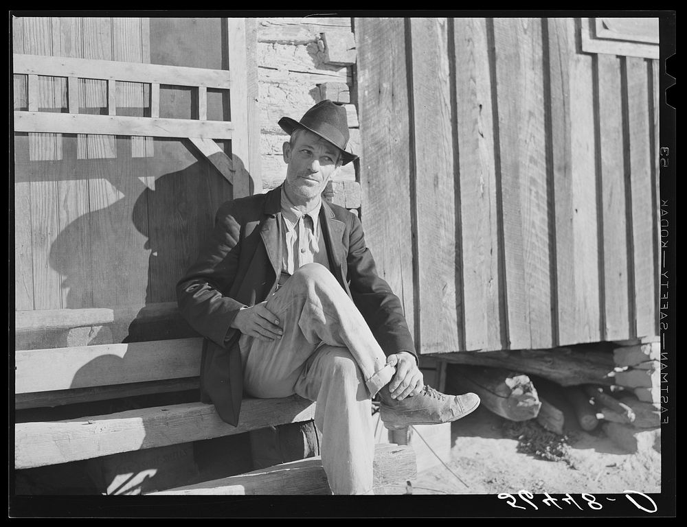 [Untitled photo, possibly related to: Noah Garland sitting on the steps of his son's home. Southern Appalachian Project near…