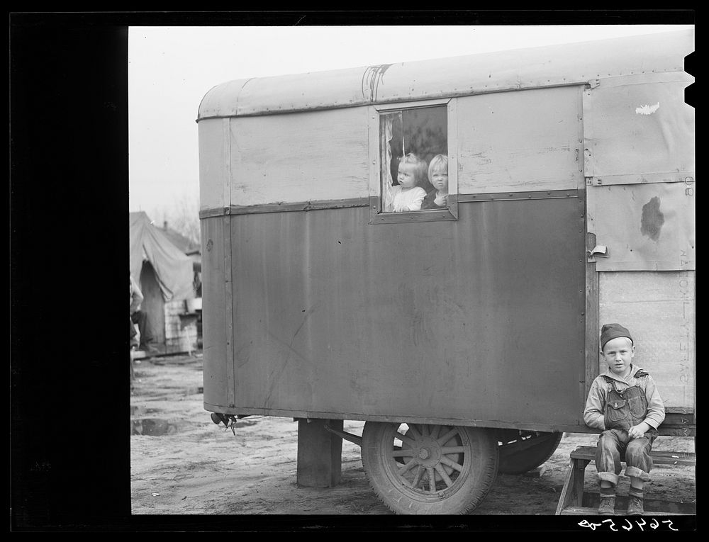 [Untitled photo, possibly related to: Children looking out of trailer window. Trailer where C.E. Children and family live in…