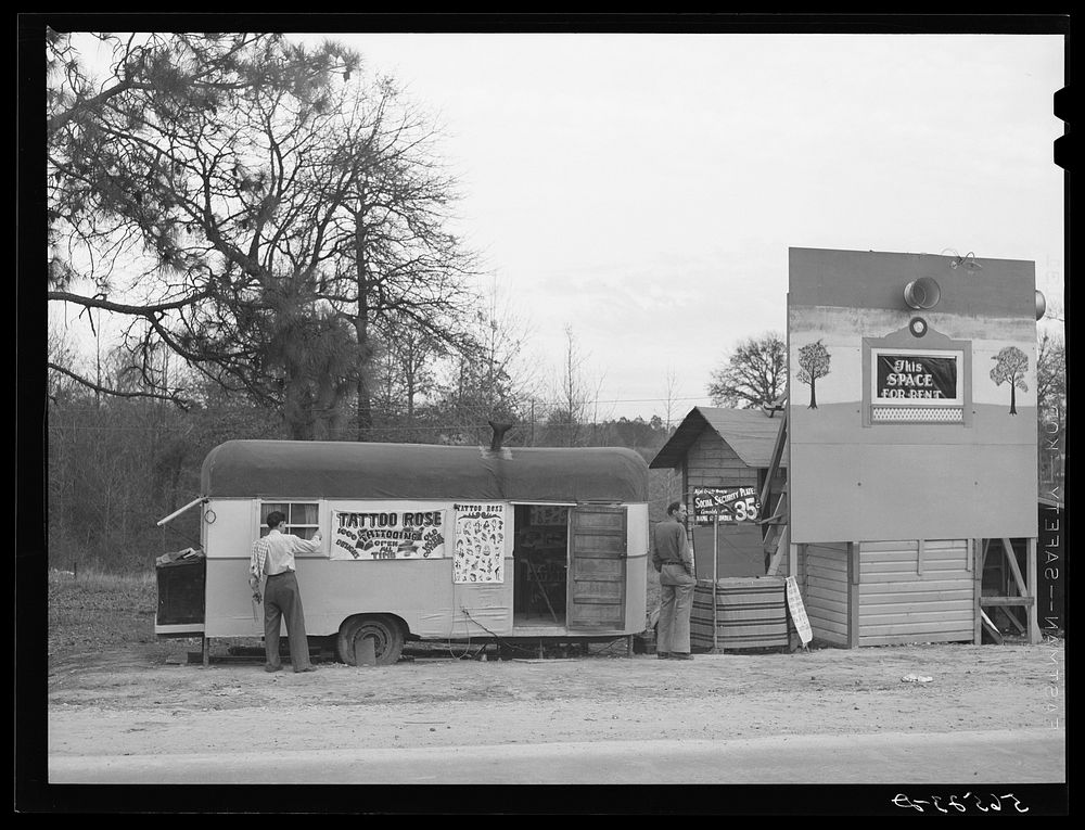 Signs and trailer with tattoo artist on highway near Fort Beauregard.  Alexandria, Louisiana. Sourced from the Library of…