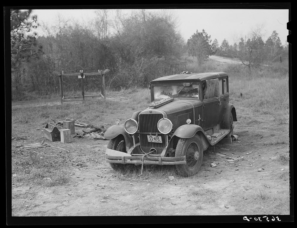 Close-up of car from Mississippi used for sleeping as well as shelter and traveling. Evidences of cooking outdoors are…