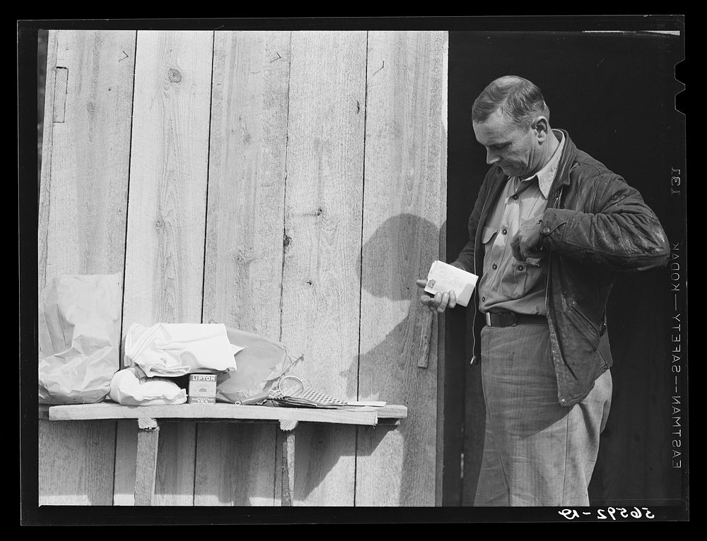 Mr. R. Jones in front of new shack built on government property near Camp Livingston with supplies he purchased in town-…