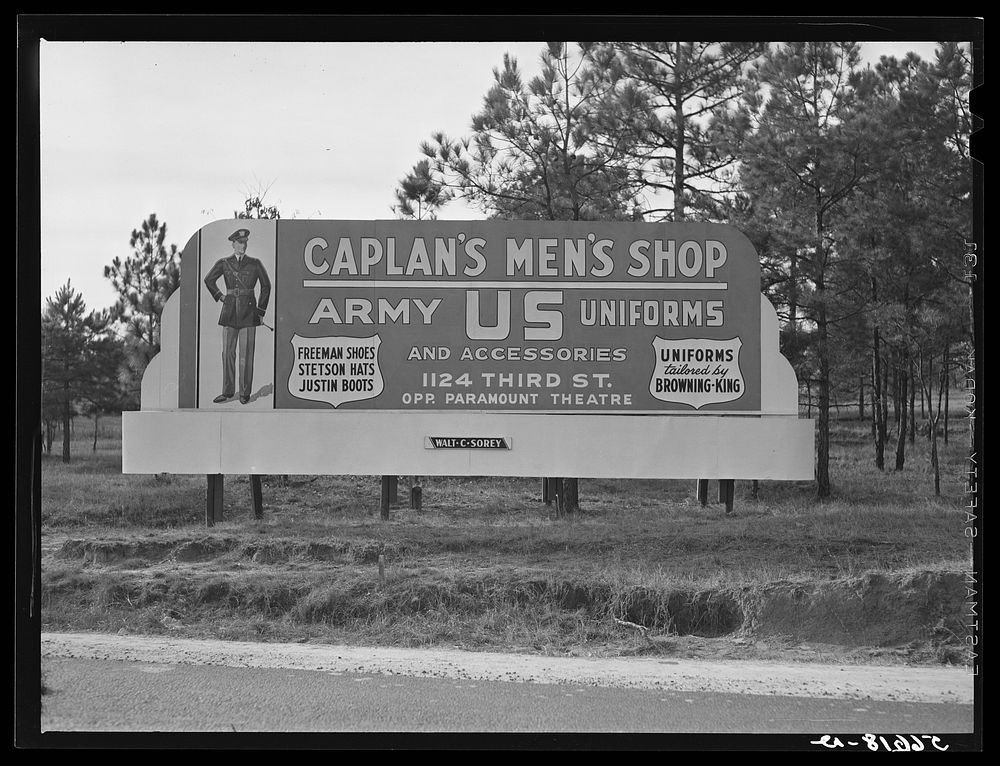 Signs opposite Camp Beauregard entrance on highway--Army uniforms, correspondence school adds, etc., on main highway between…