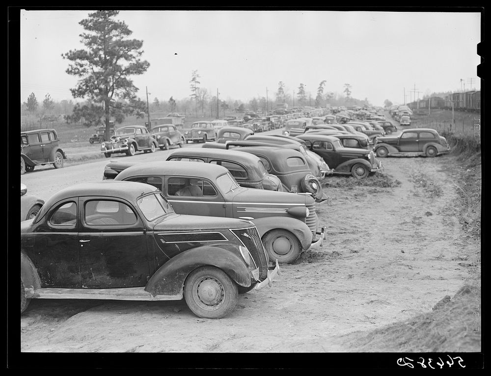 [Untitled photo, possibly related to: Parked cars off side of highway near entrance to Camp Claiborne all belonging to…