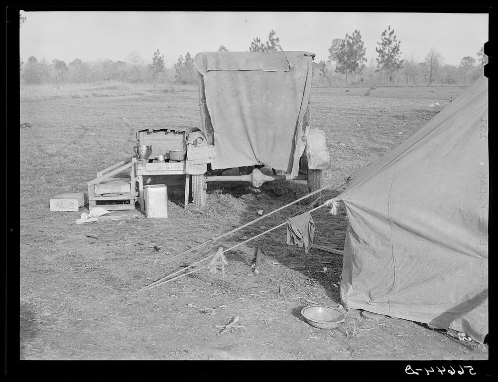 Tent and farm truck used for sleeping and general housing by construction workers off highway near Camp Claiborne. They cook…