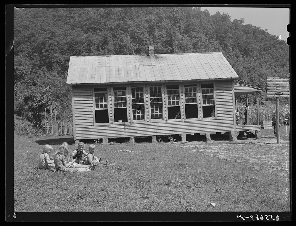 Children eating lunch during noon hour by one-room rural mountain school. Breathitt County, Kentucky. Sourced from the…