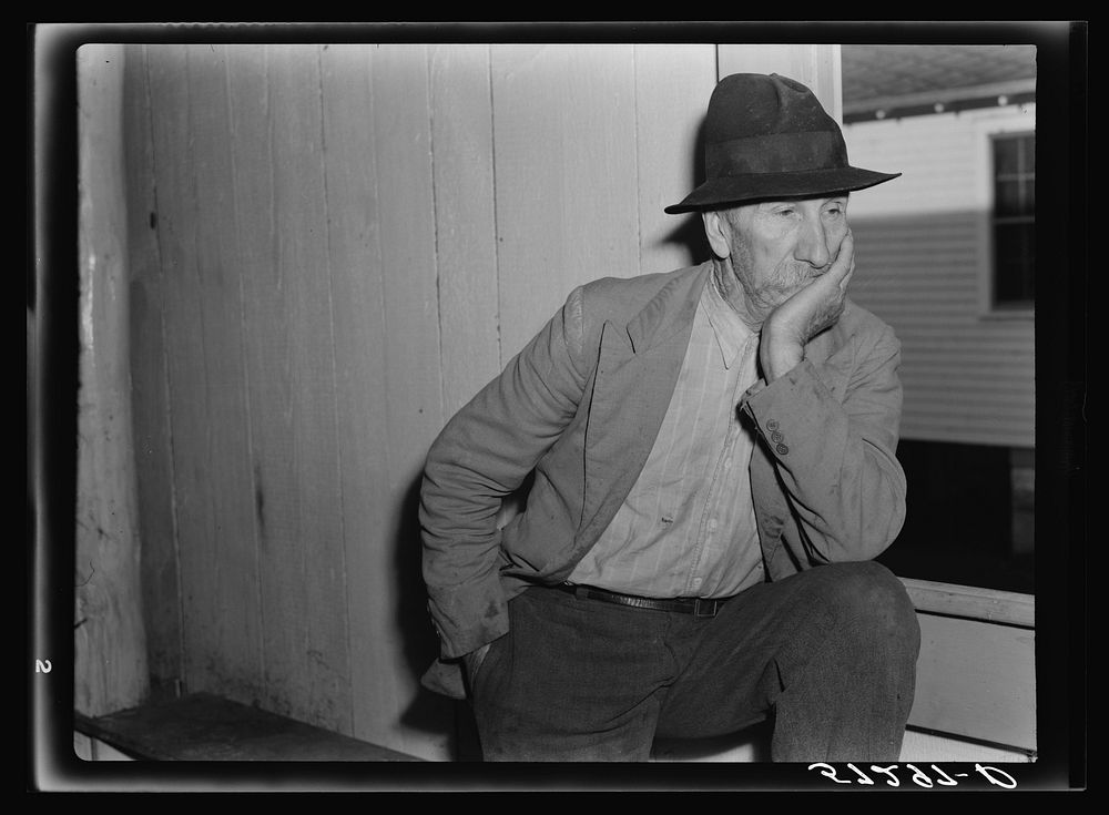 Spanish trapper watching fur auction sale in dance hall. Delacroix Island, Louisiana. Sourced from the Library of Congress.