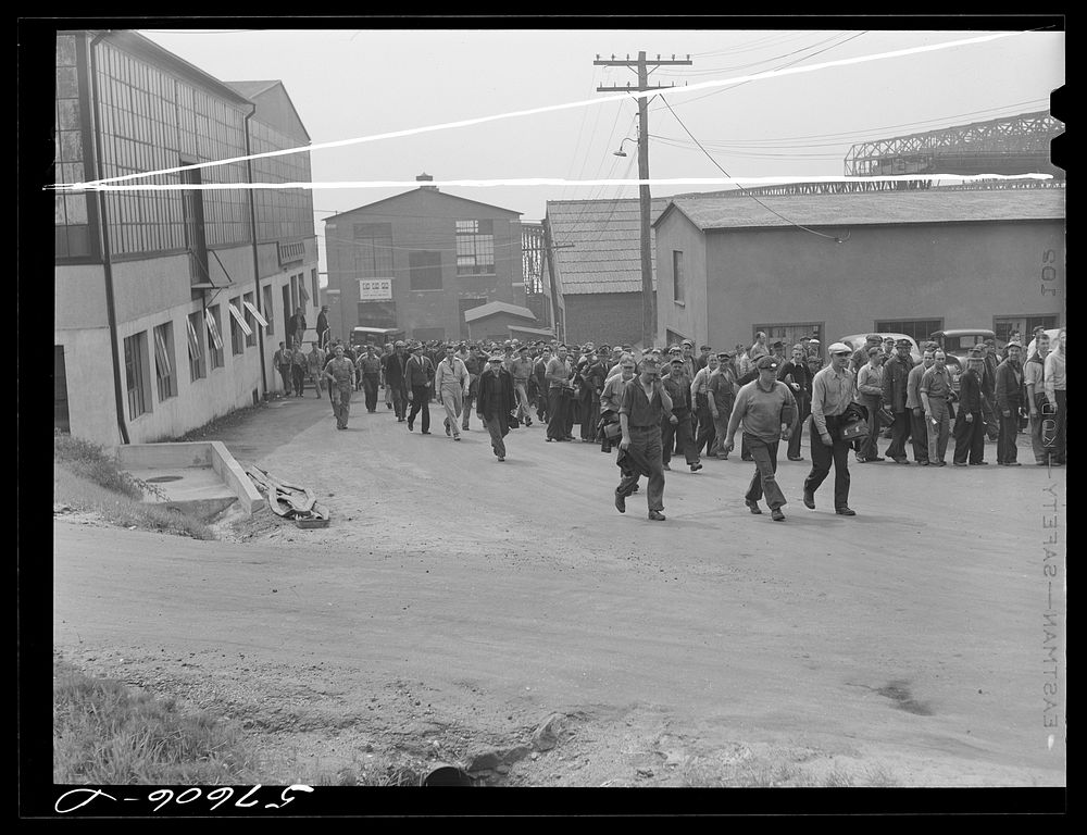 Workers coming out of the electric boat works at the afternoon change of shift. Groton, Connecticut. Sourced from the…