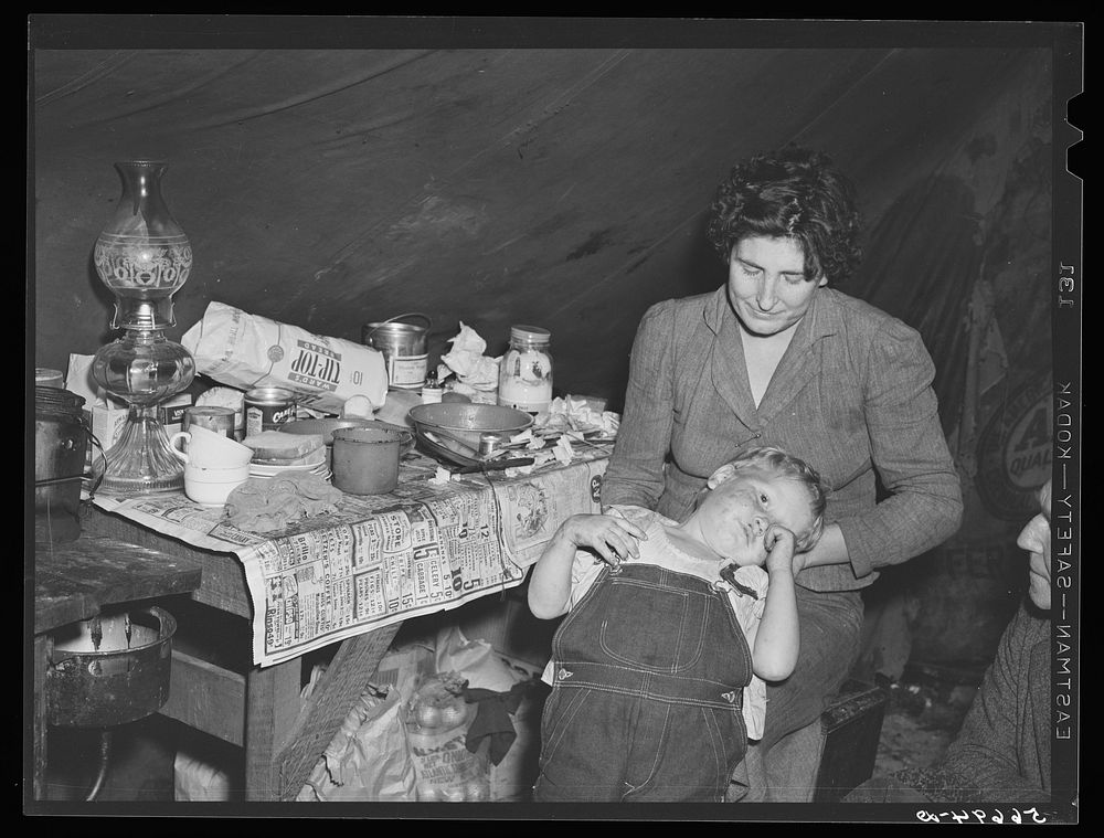 Wife and child of construction worker in tent home near Alexandria, Louisiana. Ten men, two women, and two children live…