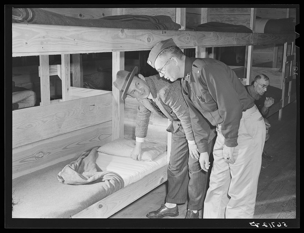 Major Cooke and Mr. O.E. Miller, personnel director for the construction company, inspecting beds inside barracks where…