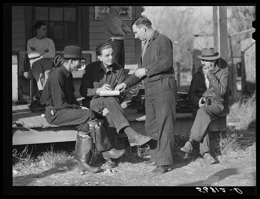 Fur buyer handing FSA (Farm Security Administration) supervisor his bid on the next lot of muskrats. The auction sale is…