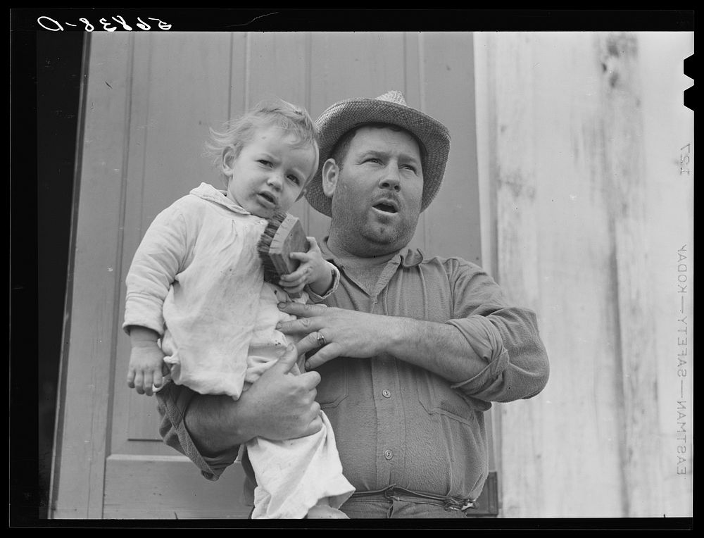 French muskrat trapper with neighbor's child. Delacroix Island, Saint Bernard Parish, Louisiana. Sourced from the Library of…