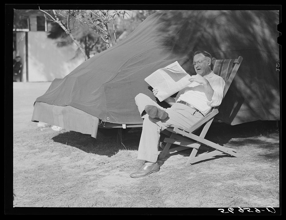 Reading newspaper. Sarasota trailer park, Sarasota, Florida. Sourced from the Library of Congress.