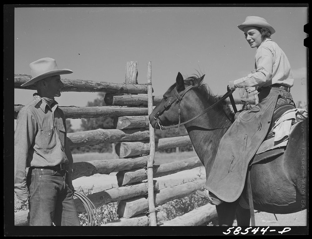 [Untitled photo, possibly related to: Dudes saddling horses in the corral before going for a ride, over the range. Quarter…