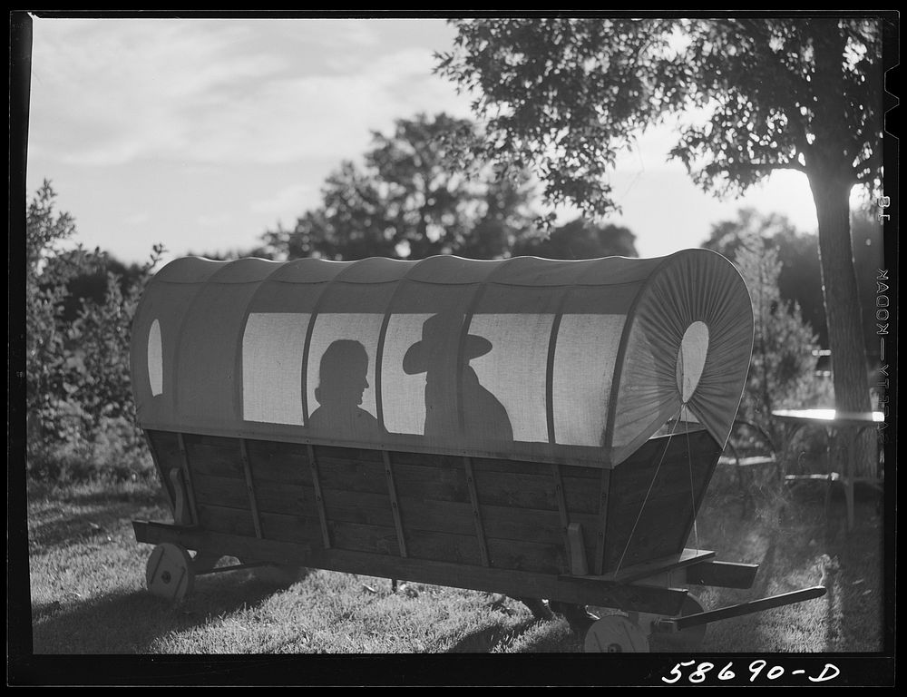 [Untitled photo, possibly related to: Dudes in a covered wagon garden seat at Quarter Circle U, Brewster-Arnold Ranch…