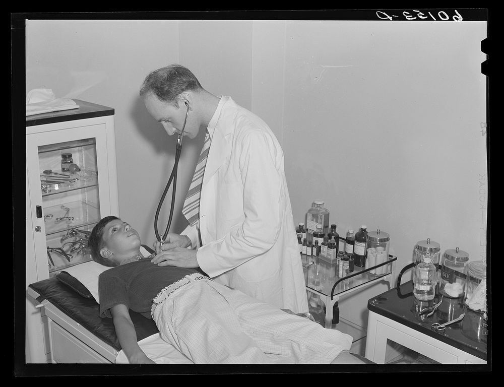 Boy being examined by doctor. Greendale, Wisconsin. This is the Greendale branch of the Milwaukee Group Health Association.…