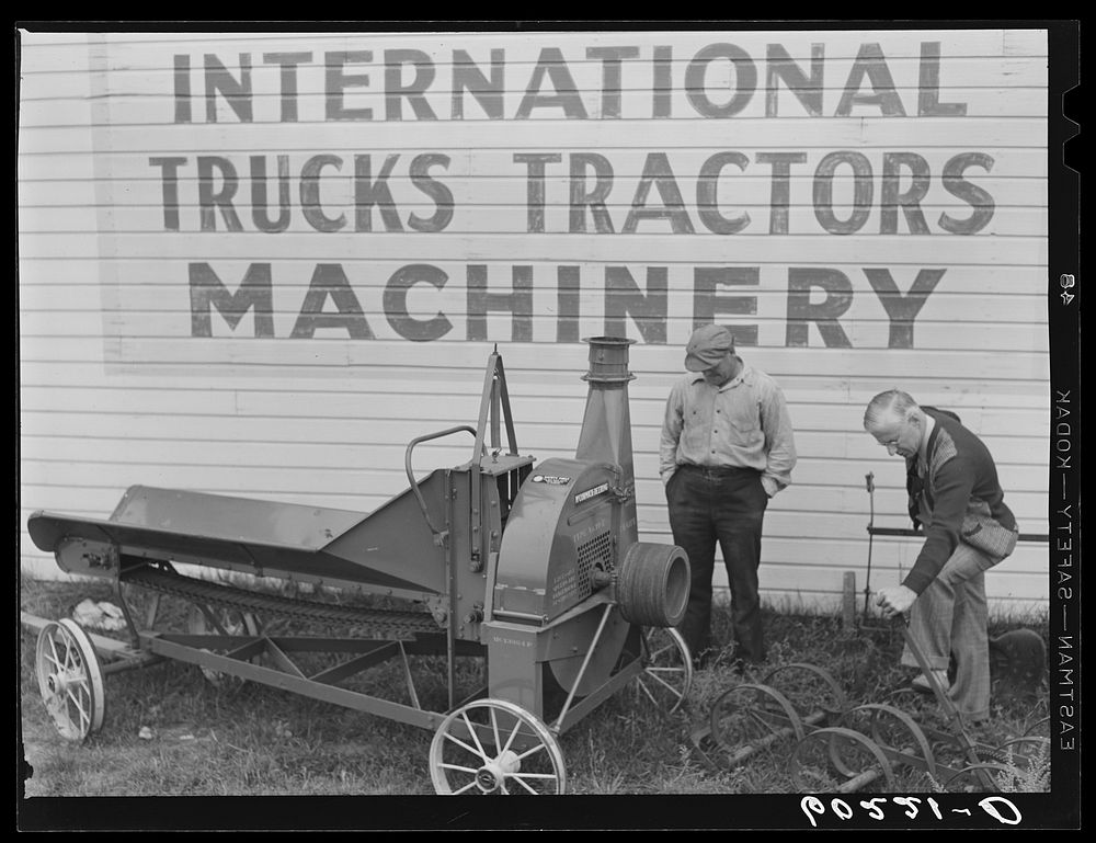 County supervisor (FSA) looking over used farm machinery with FSA (Farm Security Administration) client. Grand Rapids…