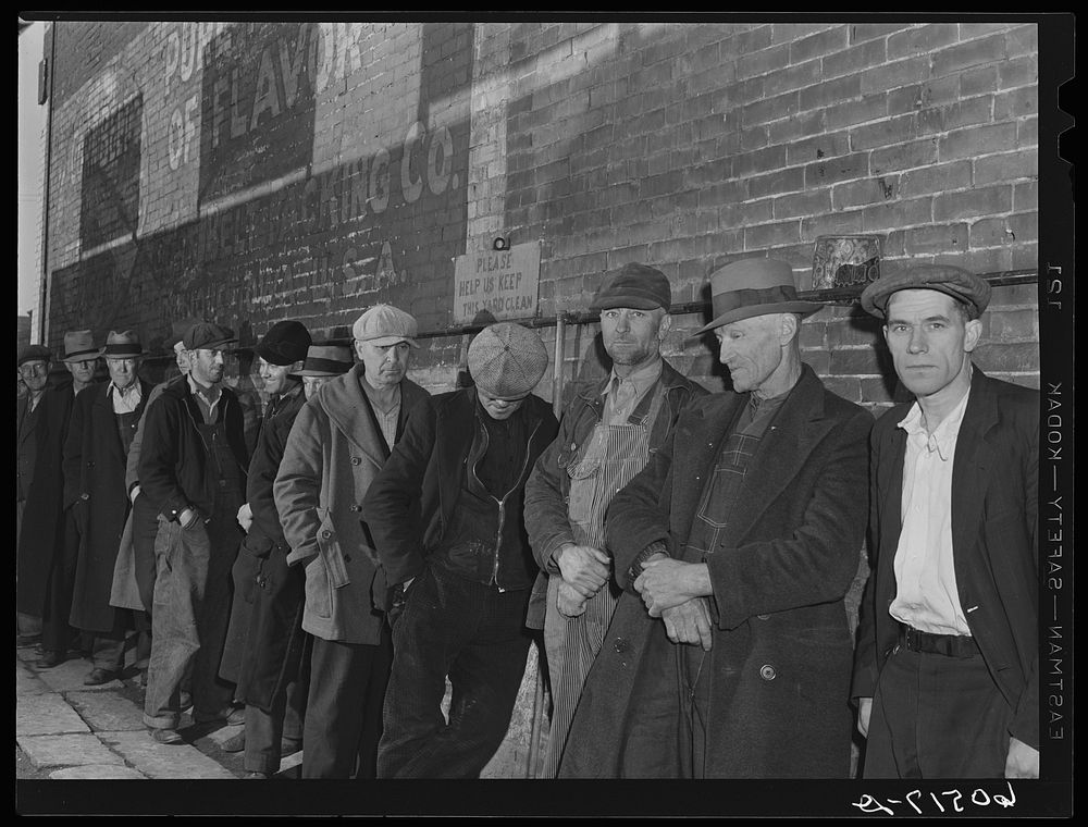 Line of men waiting in alley outside city mission. They are waiting for the meal which will be served at 5:00 p.m. Dubuque…