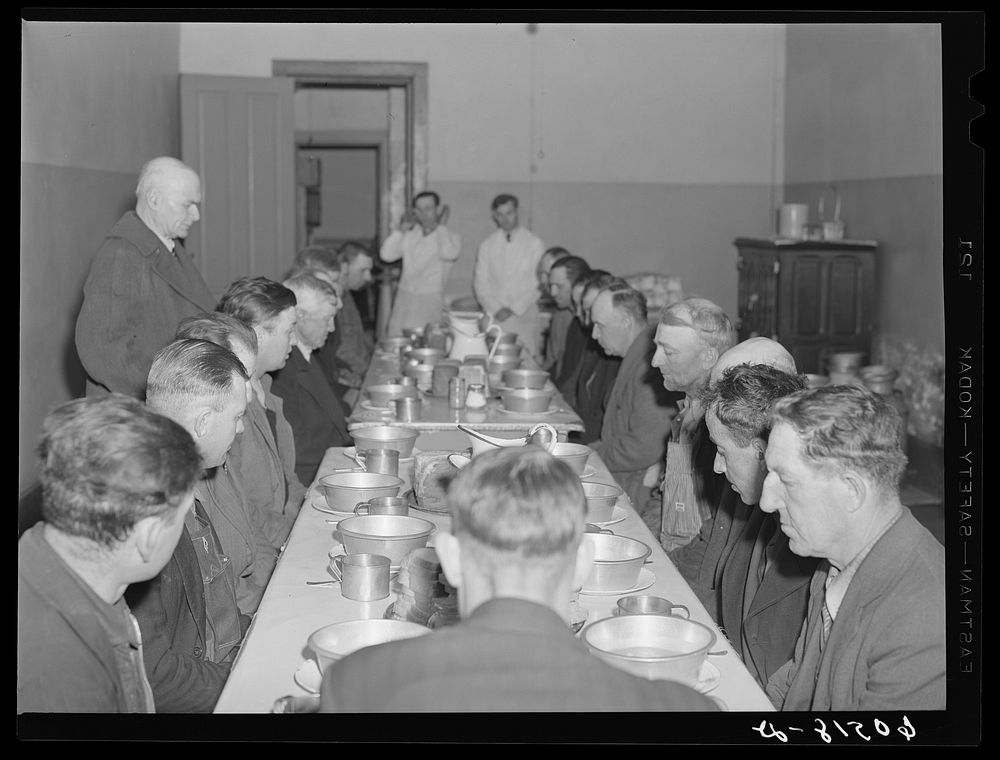 Transient men saying prayer before meal at the city mission, a community chest-financed organization. Dubuque, Iowa. Sourced…