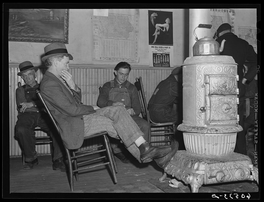 Men sitting around stove in lobby of thirty-five cents a night hotel. Dubuque, Iowa. Sourced from the Library of Congress.