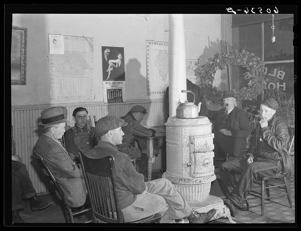 Men sitting around the stove in lobby of thirty-five cents a night hotel. Many of these men are transient men (farm…