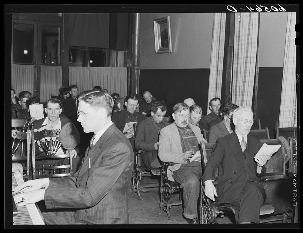 Hymn singing during evening services at city mission for homeless men. Dubuque, Iowa. Sourced from the Library of Congress.