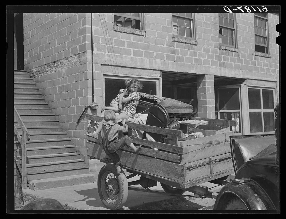 Trailer loaded with furniture of family about to move on in search of work picking fruit. Berrien County, Michigan. Sourced…