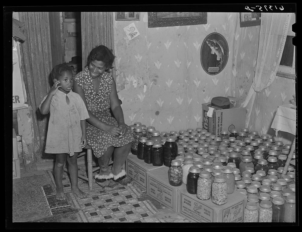 [Untitled photo, possibly related to: Mrs. Calip White and daughter with fruit and vegetables canned for the winter. Near…