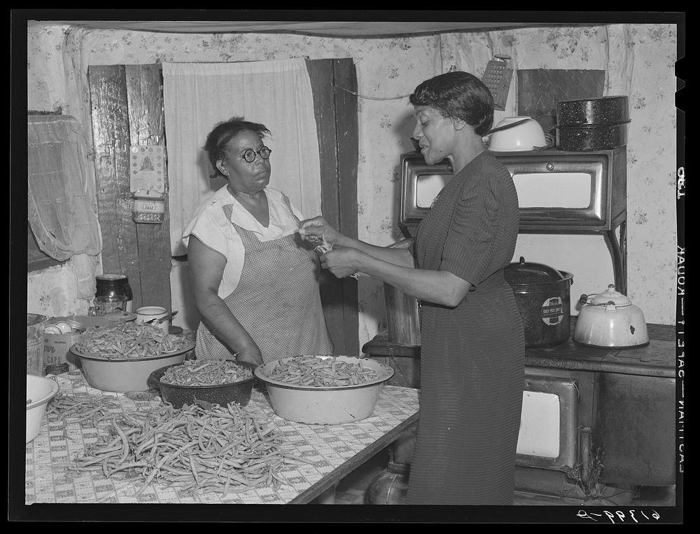 Miss Chappelle, home supervisor, helping Mrs. Smith can beans. Saint Mary's County, Maryland. Sourced from the Library of…