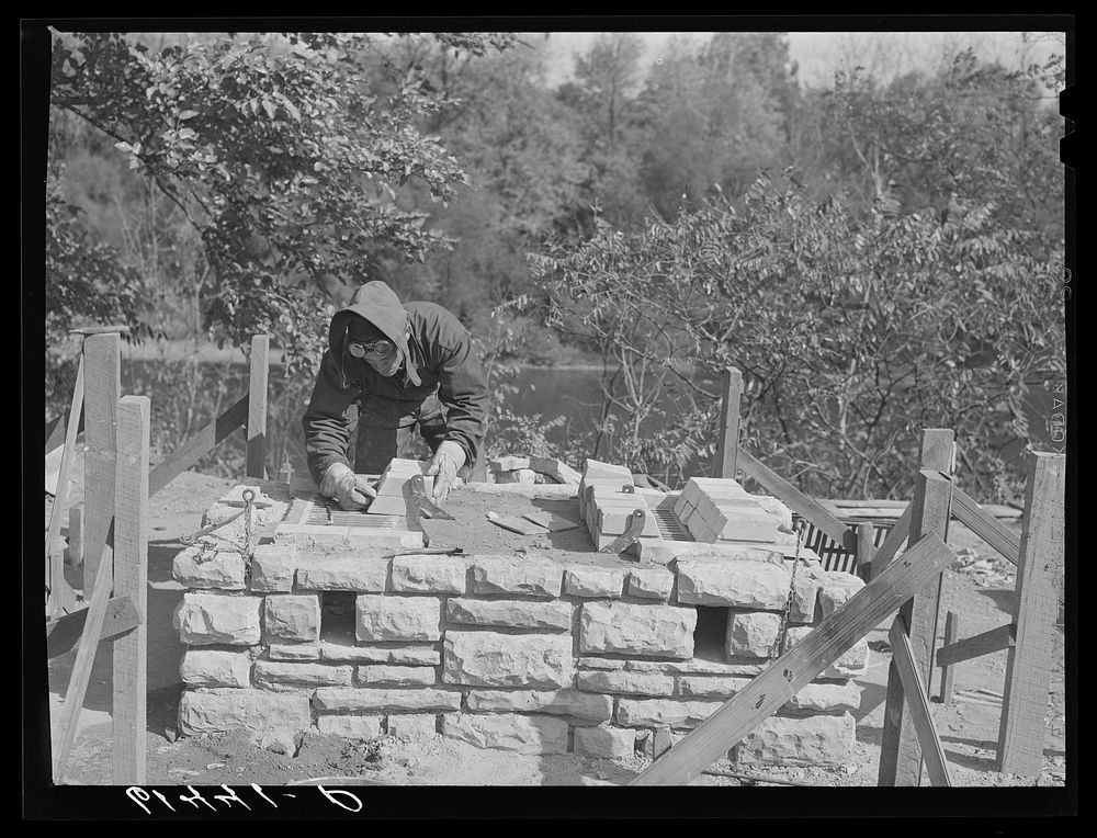 CCC (Civilian Conservation Corps) boy building charcoal burner at picnic grounds of recreation area. Ross County, Ohio.…