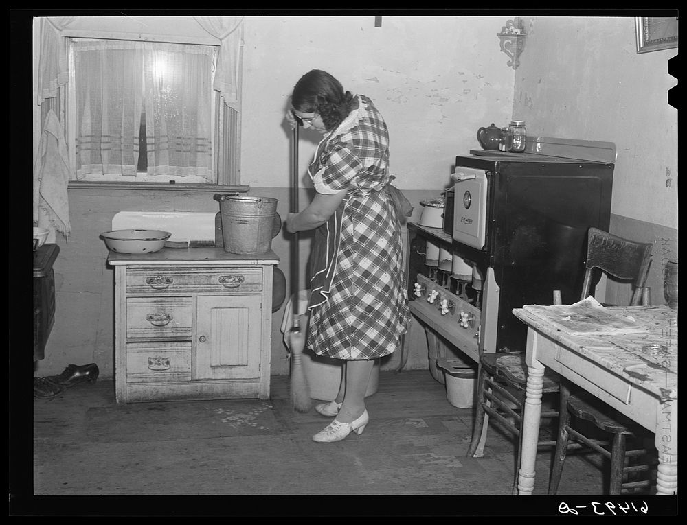 Mrs. Sauer sweeping kitchen floor. Cavalier County, North Dakota. Sourced from the Library of Congress.