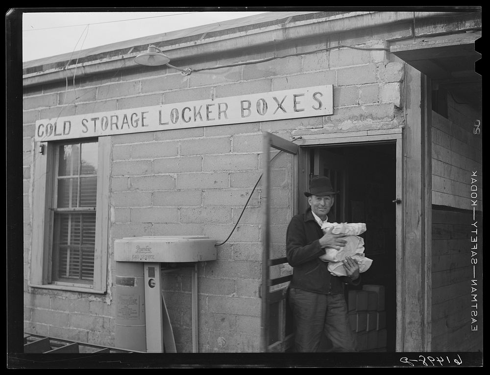 Farmer bringing food out of co-op cold storage lockers. This coop received a forty-five hundred dollar loan from FSA (Farm…