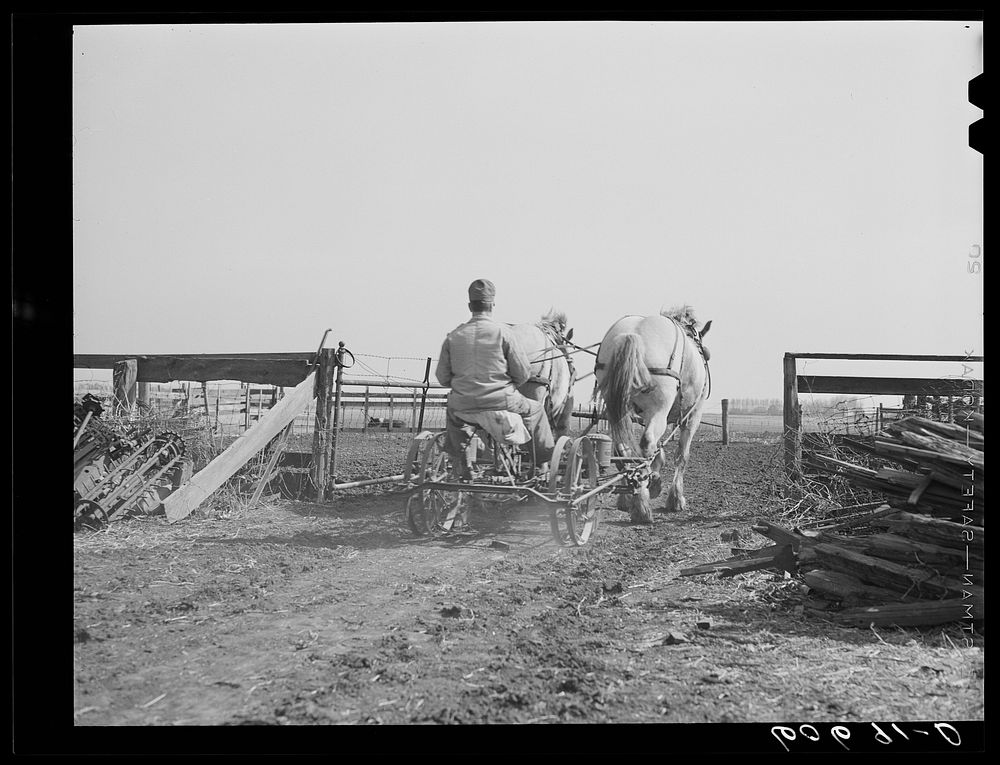 Driving two-row corn planter out of field on first day of planting. Grundy County, Iowa. Sourced from the Library of…