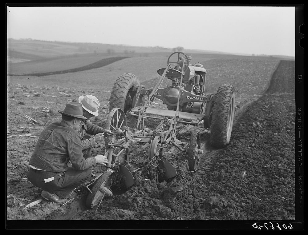 County agent helping farmer adjust plow. Jasper County, Iowa. Sourced from the Library of Congress.