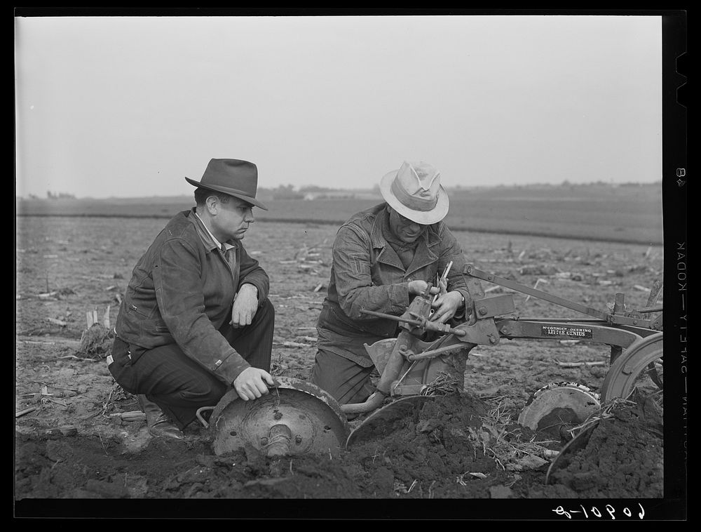 County agent watching farmer adjust plow points. Jasper County, Iowa. Sourced from the Library of Congress.