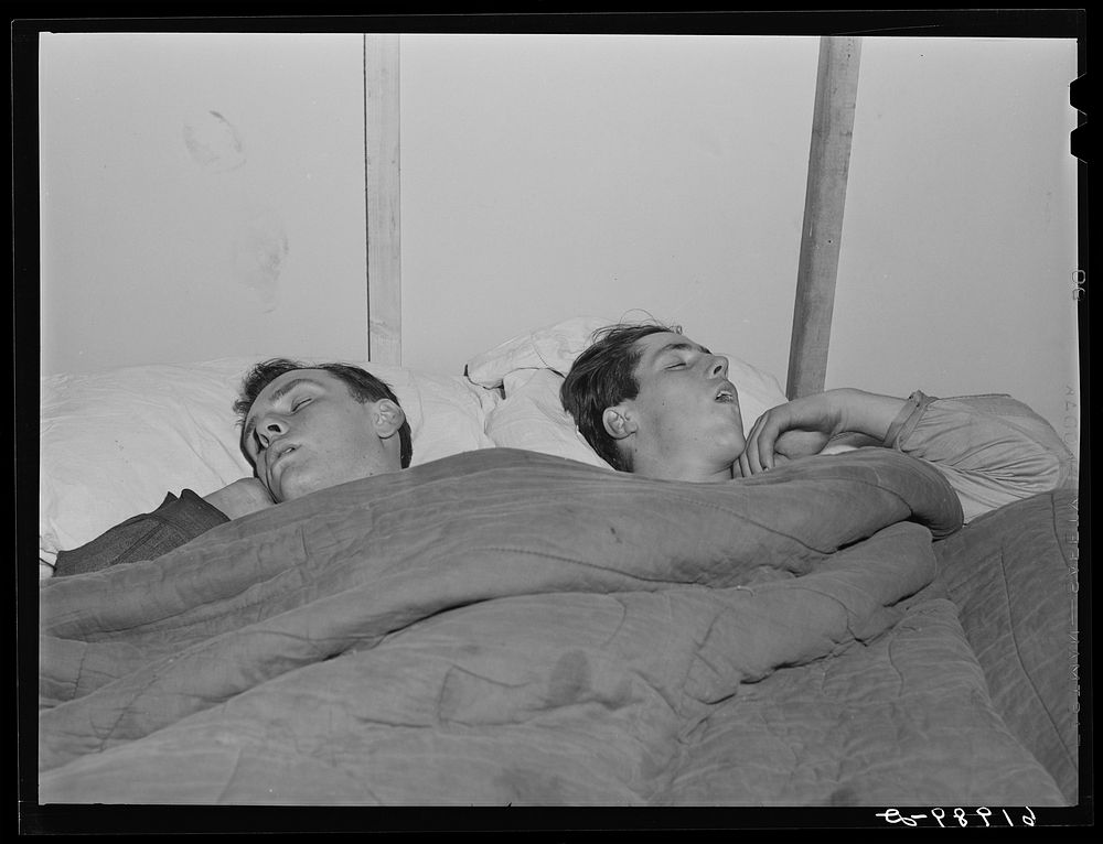 Construction workers sleeping in room in basement of secondhand furniture store. Radford, Virginia. Sourced from the Library…