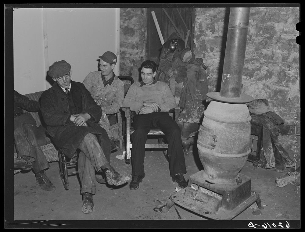 Men sitting around stove in basement of Mr. Tilly's store. He lets them sit here all night. Radford, Virginia. Sourced from…