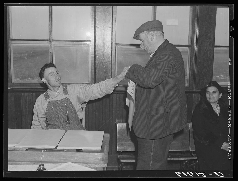 Election inspector handing ballot to farmer. Beaver Creek precinct, McIntosh County, North Dakota. Sourced from the Library…