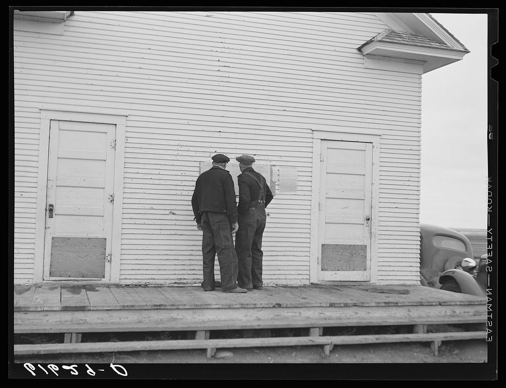 Farmers reading ballots posted outside schoolhouse. Election day, McIntosh County, North Dakota. Sourced from the Library of…