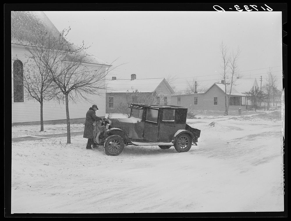 Putting blanket over auto radiator. Miller, South Dakota. Sourced from the Library of Congress.
