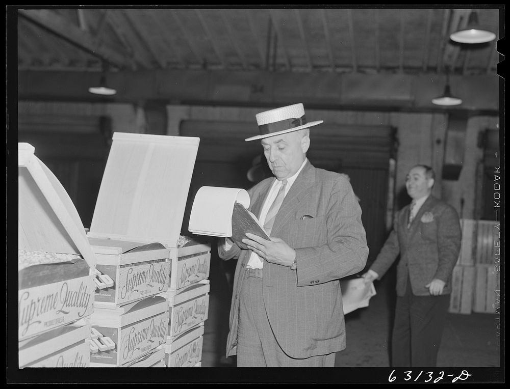 Commission merchant examining produce at fruit warehouse. Chicago, Illinois. Sourced from the Library of Congress.