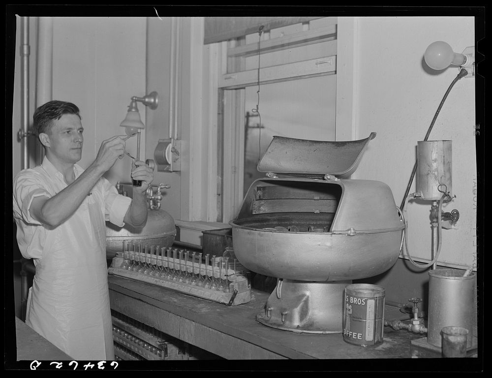 Determining butterfat content of samples of milk in laboratory of creamery. Antigo, Wisconsin. Sourced from the Library of…