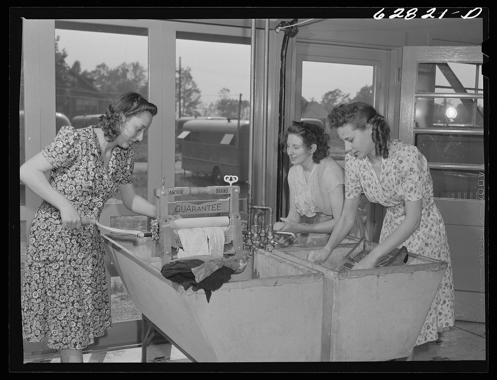 Women washing clothes in utility building at FSA (Farm Security Administration) trailer camp. Erie, Pennsylvania. Sourced…