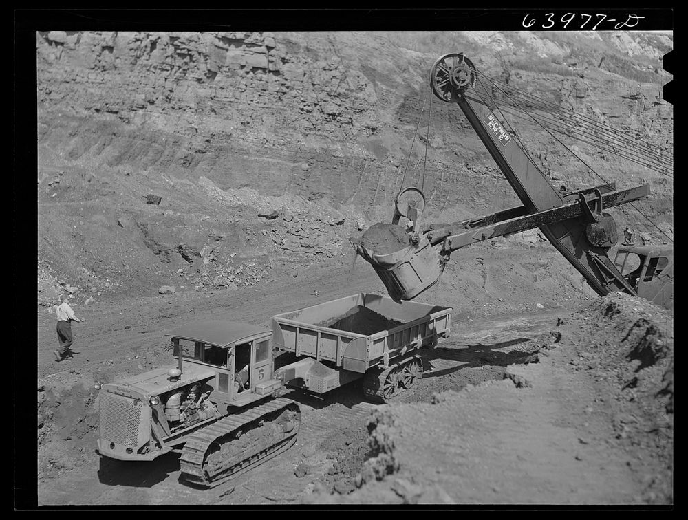 [Untitled photo, possibly related to: Loading truck with iron ore at the Albany mine near Hibbing, Minnesota. Use of trucks…