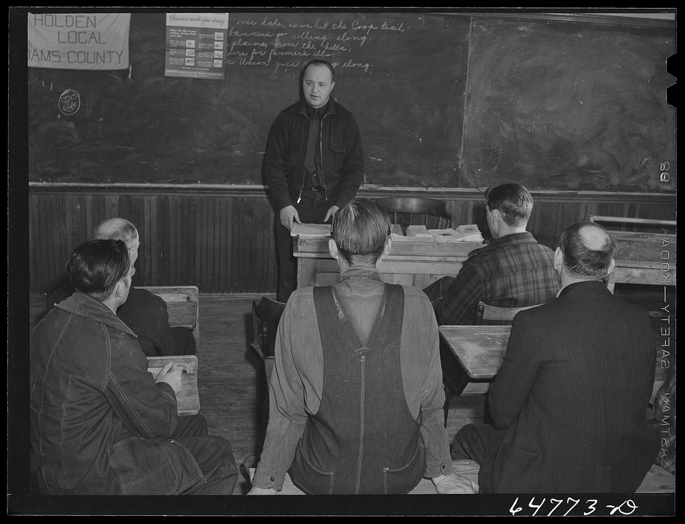 Adams County, North Dakota. County agent addressing farmers Food for Victory meeting in a rural schoolhouse. Sourced from…